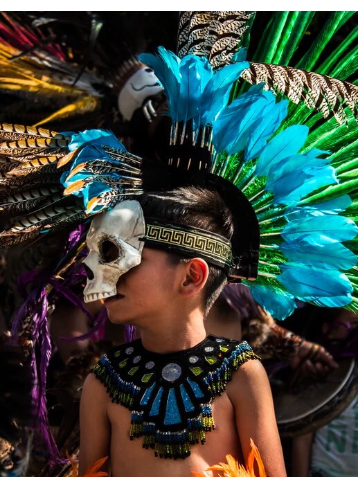 Babel Agile ING. Child dressed up with colored feathers and a skull